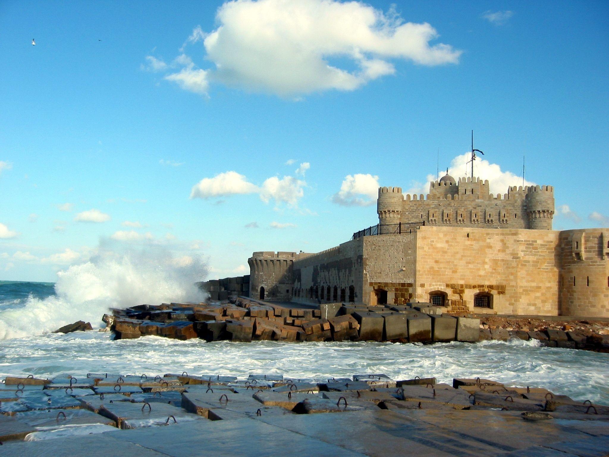 Mamluk fortress of Qaitbay with waves crashing against its seafront seawall in Alexandria