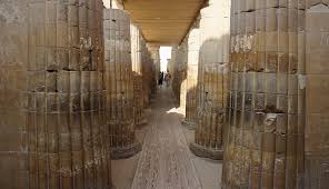A long corridor flanked by tall ancient Egyptian fluted stone columns at Saqqara