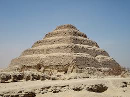 The ancient stepped pyramid of Saqqara rising in tiers against a clear blue sky