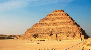 The ancient Step Pyramid of Saqqara rising in tiers against a clear blue sky