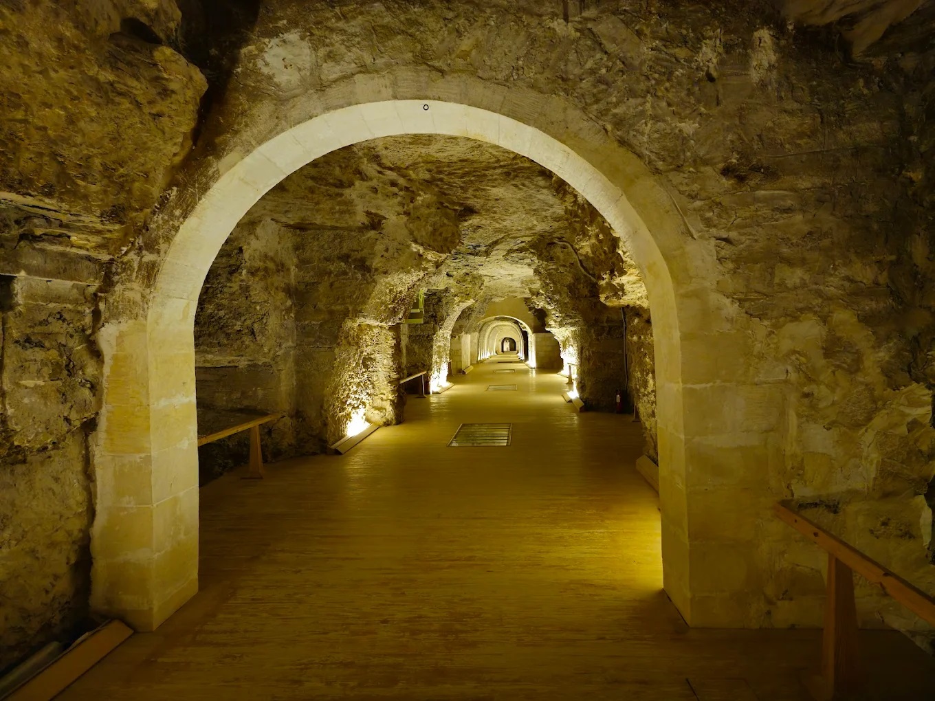 Illuminated stone arched corridor stretching deep underground at the Serapeum of Saqqara