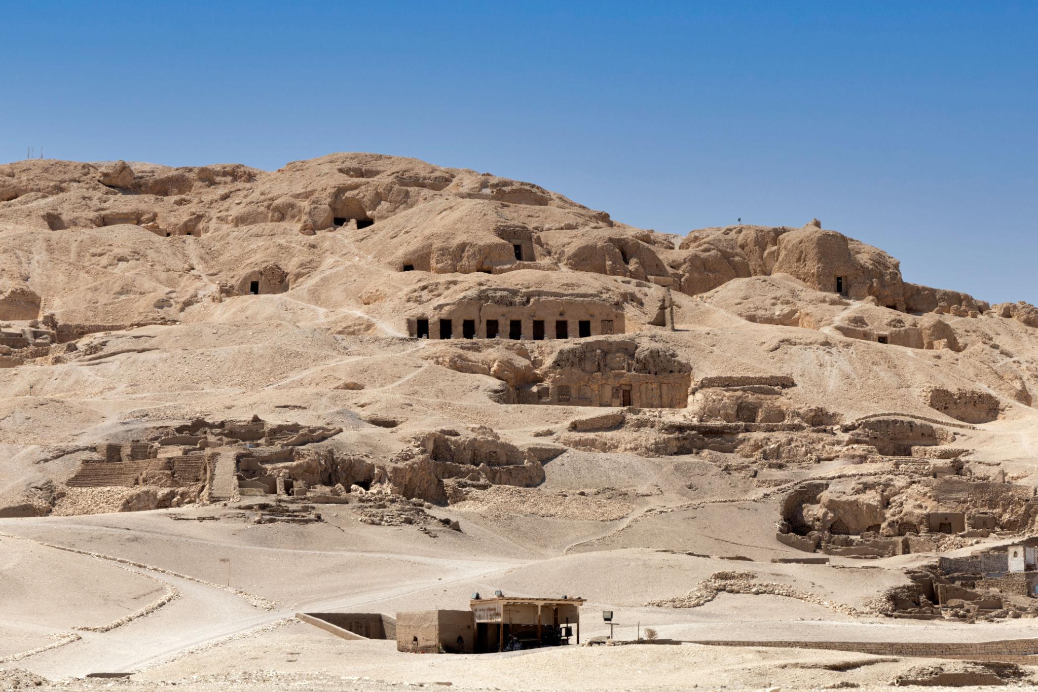 Hillside honeycombed with rock-cut tomb entrances of Luxor's Theban nobles.