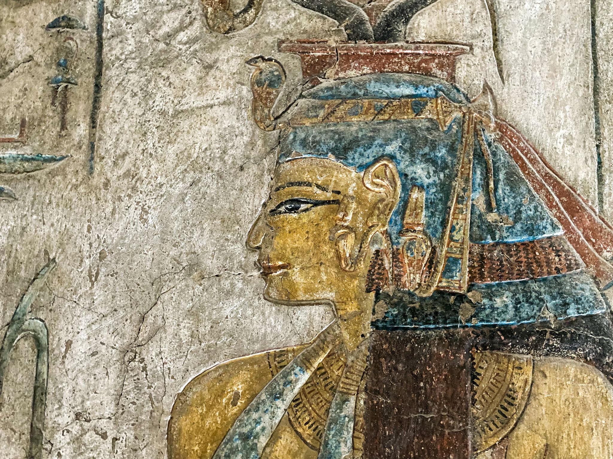 Close-up of a painted noblewoman wearing wig and ceremonial headdress.