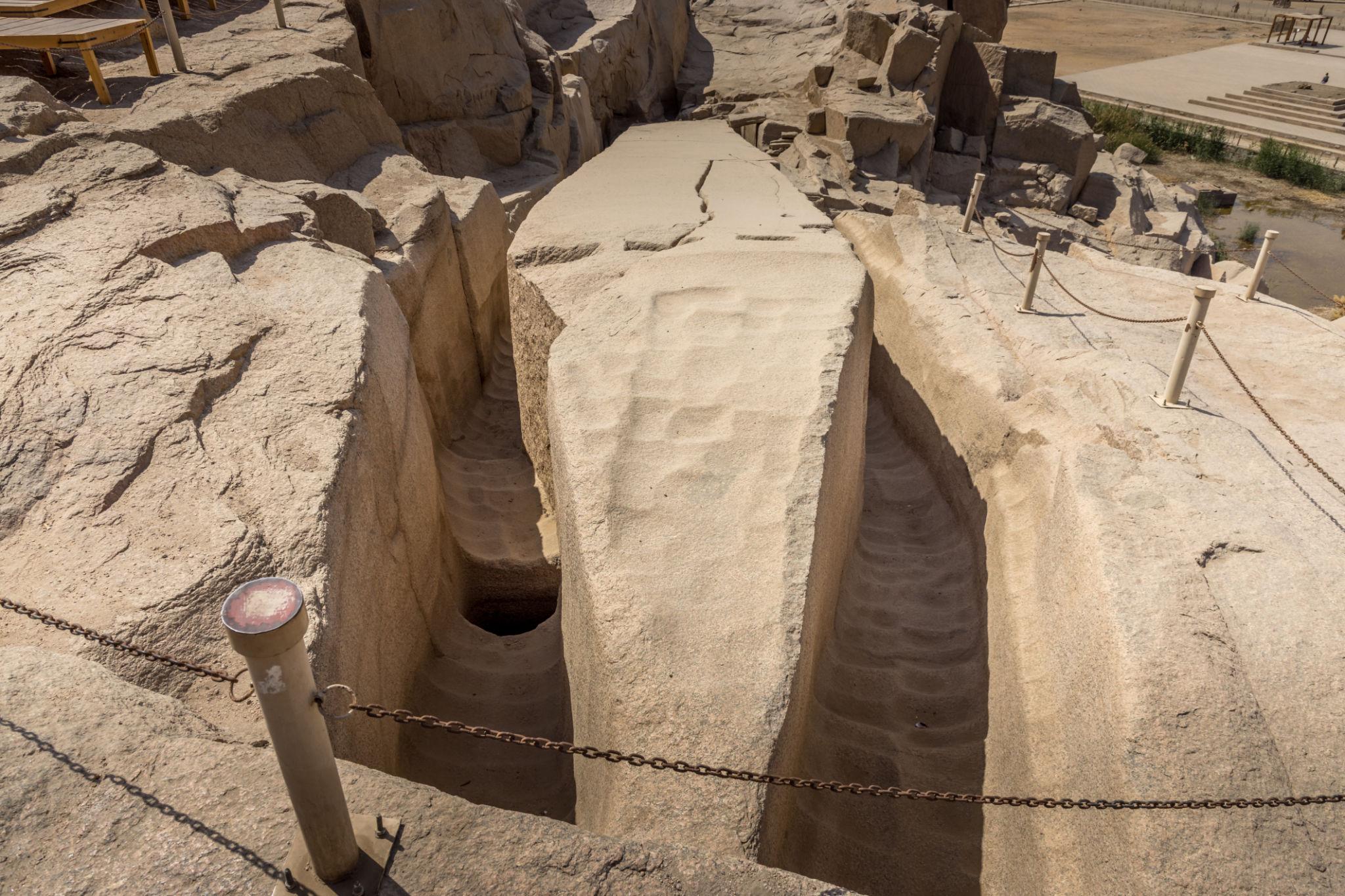 Deep carved trenches in granite bedrock reveal ancient quarrying techniques at the Unfinished Obelisk site.