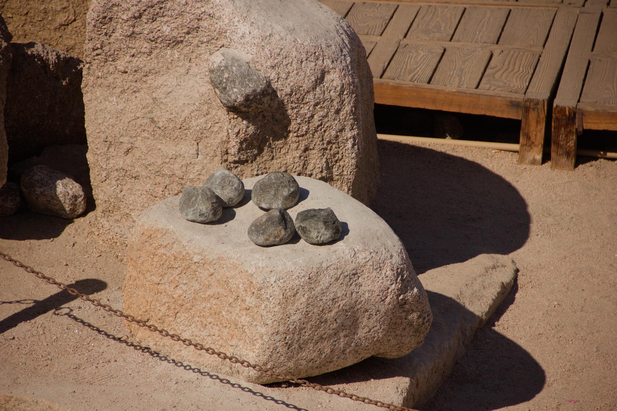 Small dark stones placed on a large granite boulder near the Unfinished Obelisk site.