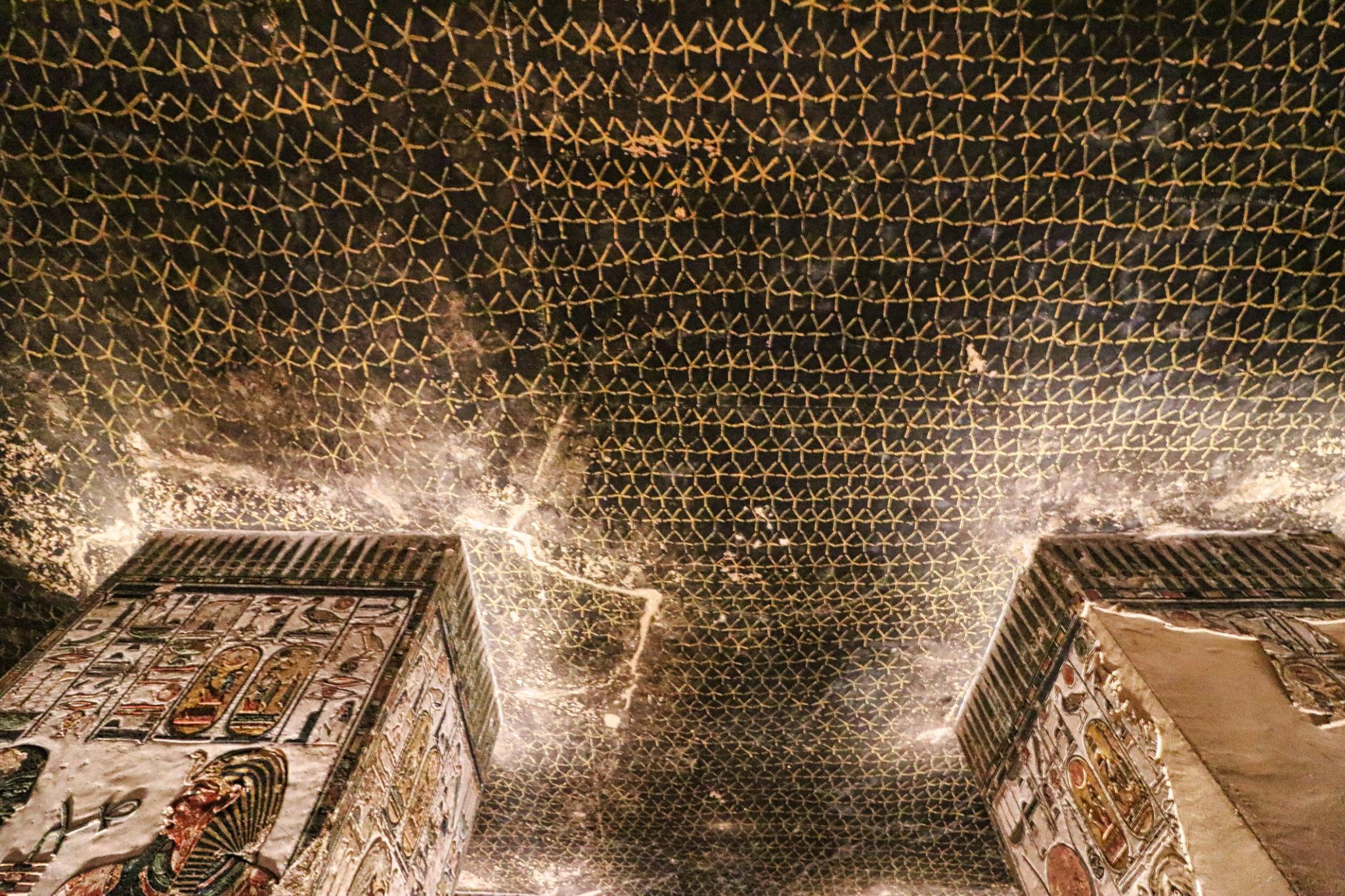 Astronomical ceiling with decans and sarcophagus plinths seen from below inside a tomb.