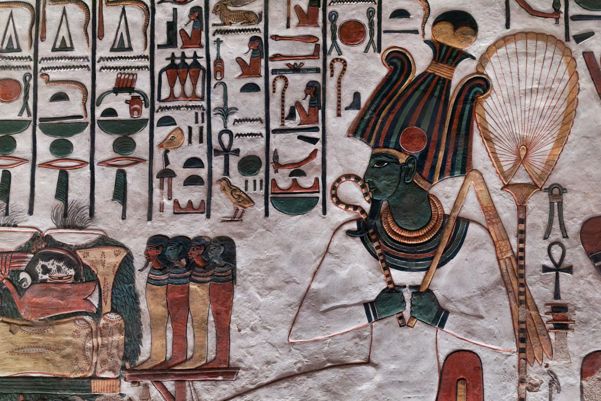 Green-skinned Osiris seated with crook and flail amid hieroglyphic text.