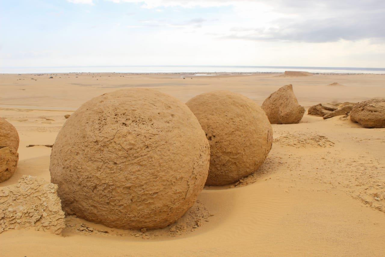 Giant spherical sandstone concretions rising from the desert sand at Wadi Al-Hitan, Egypt