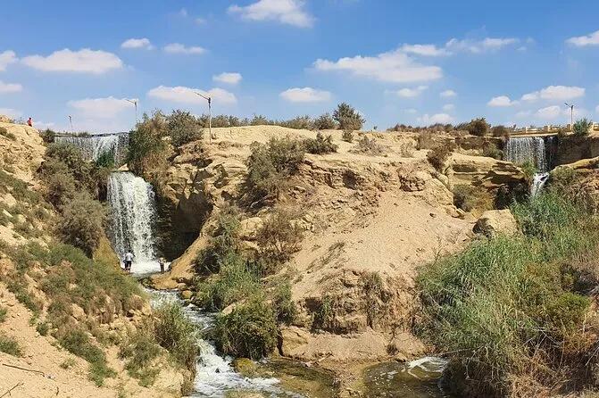 Twin desert waterfalls cascading through a sandstone canyon